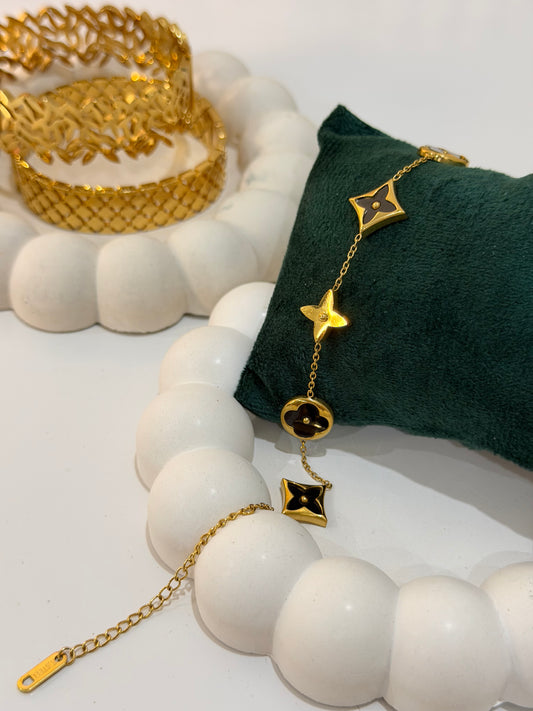 Gold bracelet with black enamel charms
