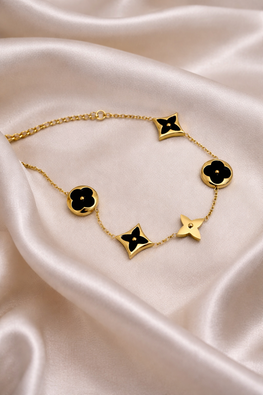 Gold bracelet with black enamel charms